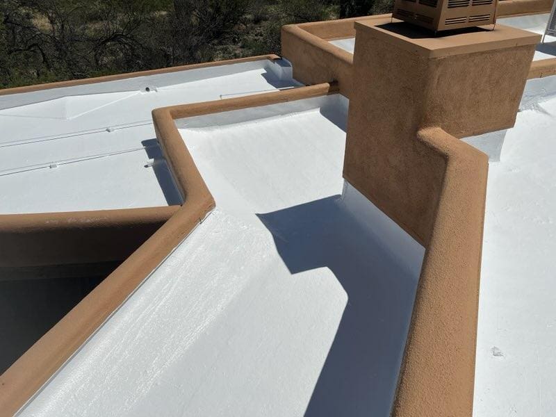 Flat rooftop with fresh white coating, highlighting detailed repair work by a roofing maintenance company.